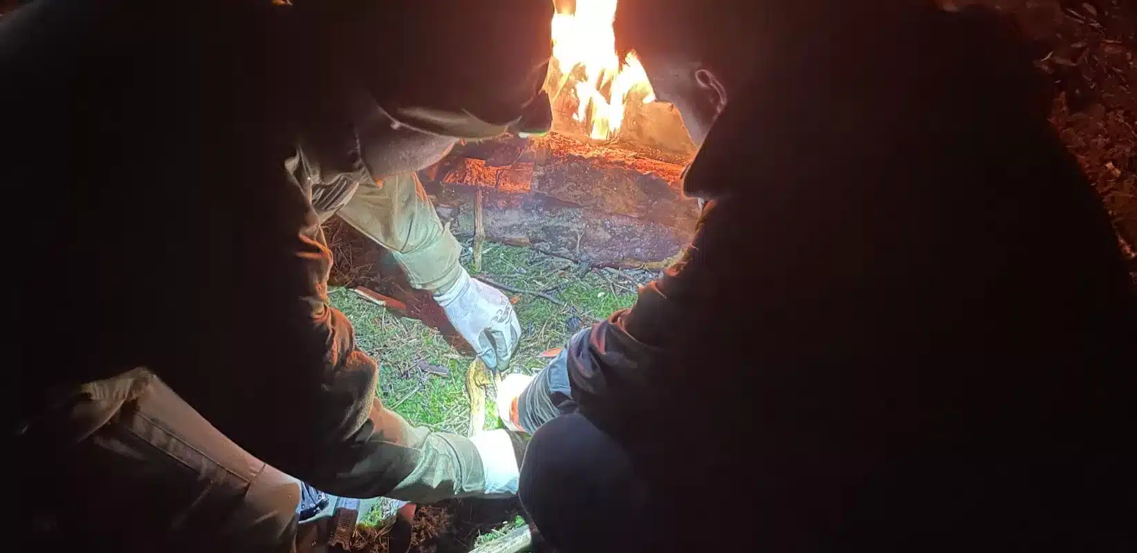 Instruktor indywidualnie uczy rozpalania ogniska noca