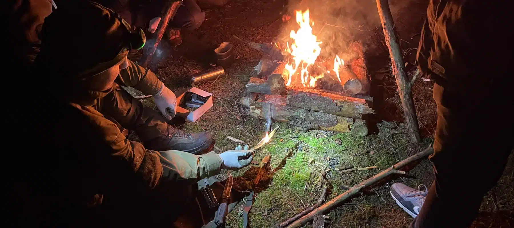 Instruktor survivalu pokazuje rozpalanie z ogniskiem studnia